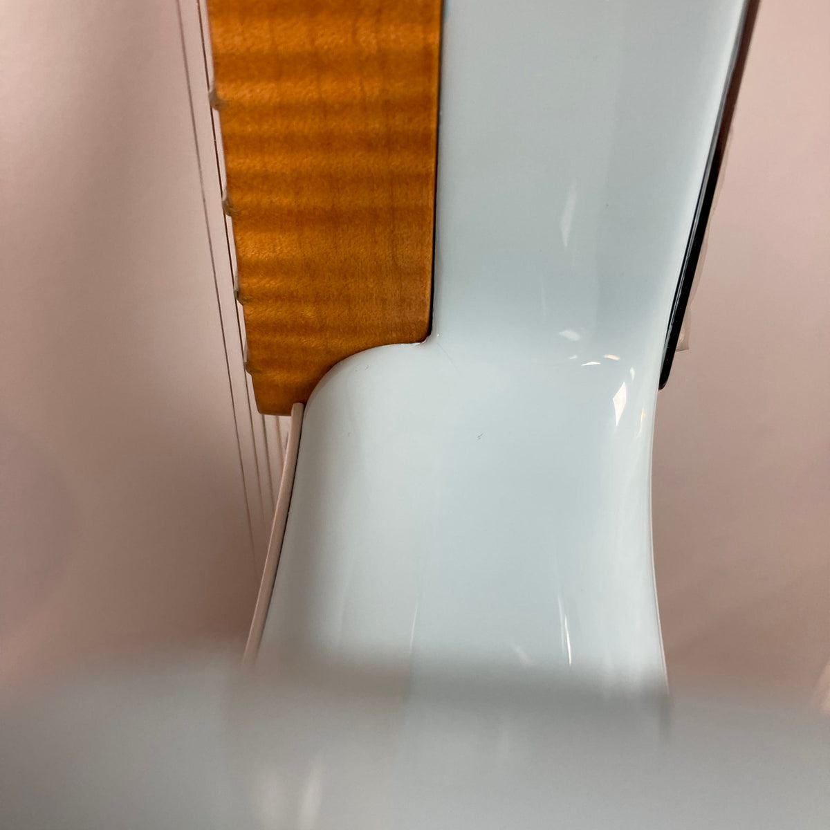 Fender Vintera '50s Stratocaster Sonic Blue USED; close-up of flamed-maple neck fitting into body, highlighting a subtle finish crack at neck pocket.