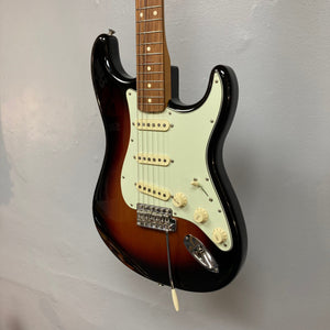 Fender Vintera '60s Stratocaster 3-Tone Sunburst Refurb w/Gigbag, featuring classic-style tremolo bridge and Tim Shaw-designed pickups, displayed on a wall.