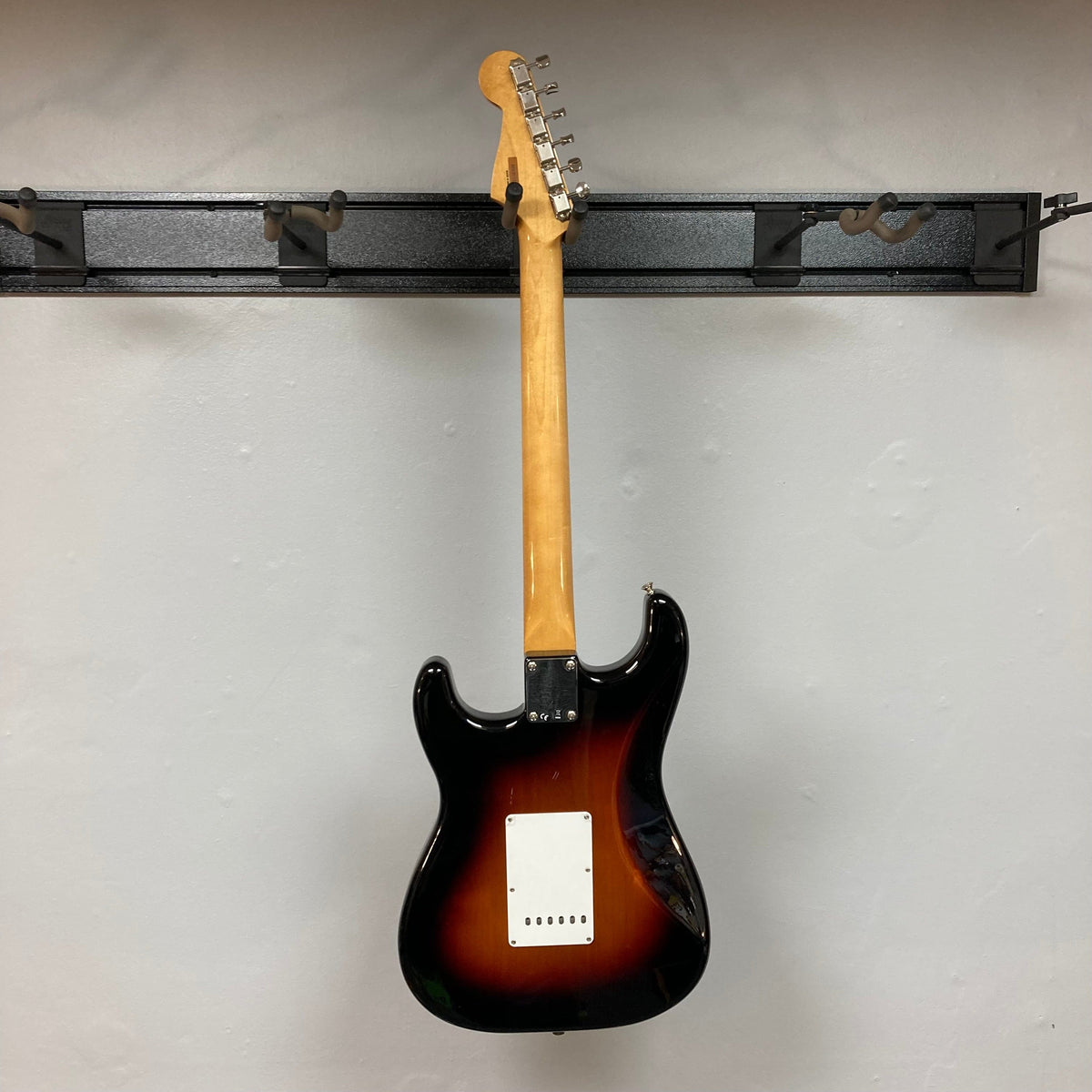 Fender Vintera '60s Stratocaster 3-Tone Sunburst Refurb w/Gigbag, featuring a classic-style tremolo bridge and Shaw-designed '60s pickups, mounted on a wall.