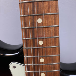 Fender Vintera '60s Stratocaster close-up showing tremolo bridge, pickups, and guitar neck detailing vintage design and craftsmanship.