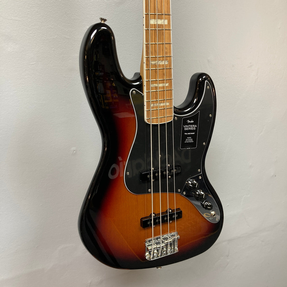 Fender Vintera '70s Jazz Bass displayed on wall, highlighting its vintage design and jazz bass features.