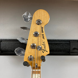 Fender Vintera '70s Jazz Bass neck close-up, showcasing vintage-style tuners and block inlays, highlighting its classic 1970s design and craftsmanship.