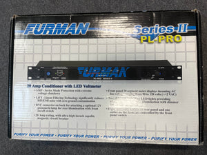 A Furman PL-Pro II Series II Power Conditioner with LED Voltmeter (Used – Like New) box features blue Furman branding, technical specs, and highlights a 20-amp power conditioner and LED voltmeter on a grid-patterned background.