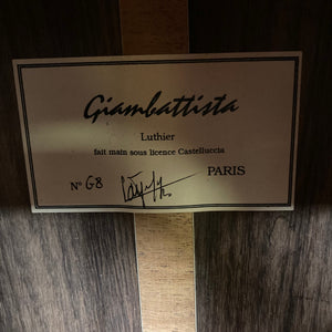 Giambattista G8 Natural Used classical guitar, showcasing signature craftsmanship on a wooden surface, highlighting its detailed label and elegant finish.