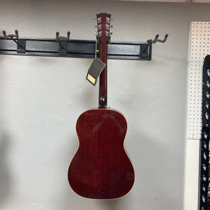 Gibson B-25 Acoustic Guitar Natural 1968 hanging on a wall, showcasing distinctive vintage checking and craftsmanship.