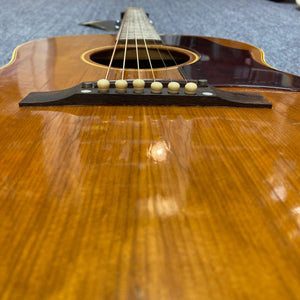Close-up of a 1968 Gibson B25 acoustic guitar, showcasing its vintage craftsmanship and distinctive checking.
