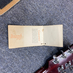 Gibson B-25 Acoustic Guitar Natural 1968 with paper tag attached, showcasing vintage checking and craftsmanship.
