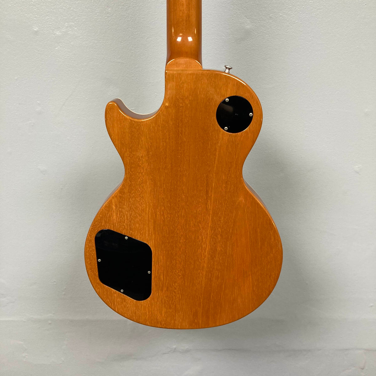 The back of the Gibson Custom Shop Class 5 Les Paul electric guitar features a natural flame maple finish and two black plastic control cavity covers.