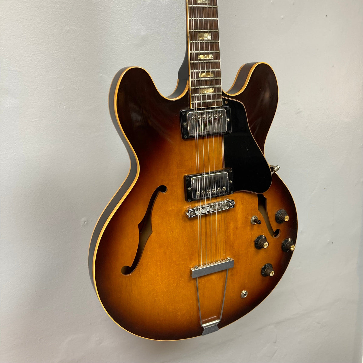 Gibson ES-335TD-12 1968 Sunburst electric guitar, semi-hollow body, 12-string, displayed on a wall; vintage craftsmanship and iconic design.