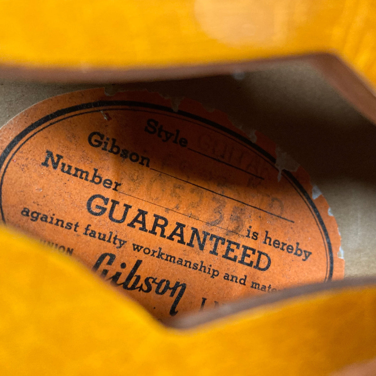 Gibson ES-335TD-12 1968 Sunburst guitar with label visible on the body, showcasing the iconic double-cutaway design and detailed craftsmanship.