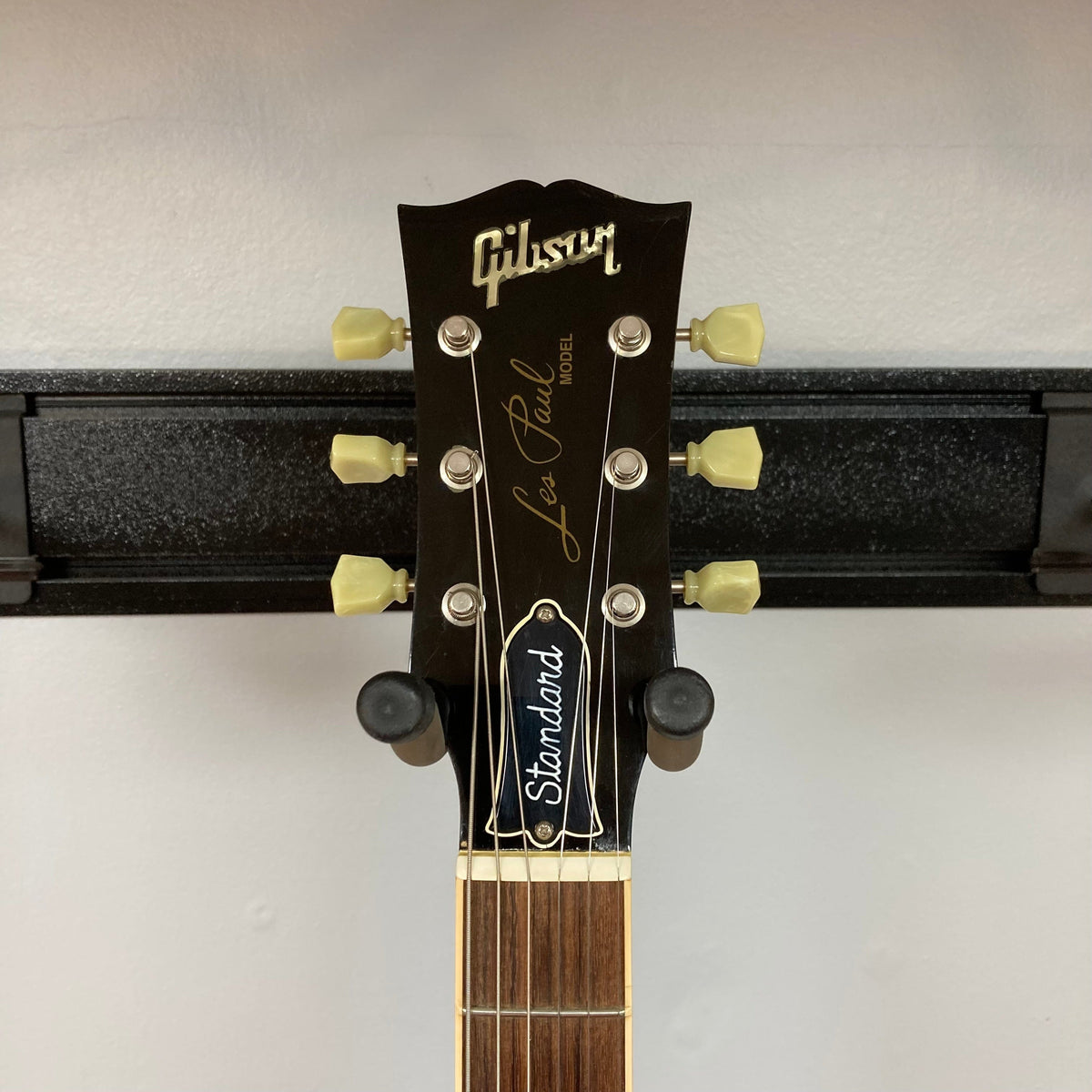 Gibson Les Paul Standard Premium Plus 2003 Ice Tea Burst guitar head on a stand, showcasing its iconic design and craftsmanship.