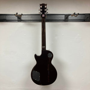 A Gibson Les Paul Studio 2015 Desert Burst electric guitar by Gibson, shown from the back on a wall mount with locking tuners and rear access panels—an upgraded instrument for serious players. Includes case.