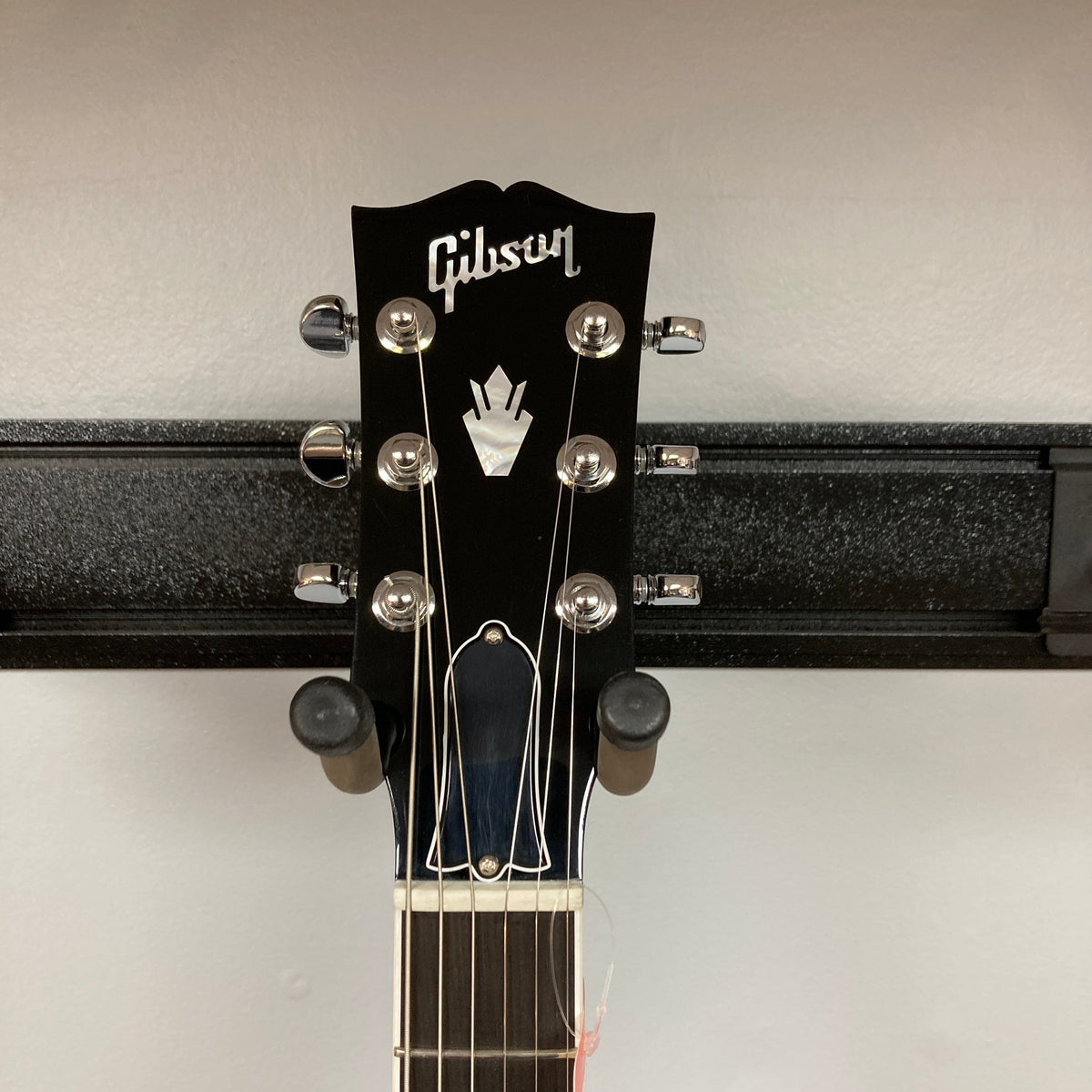 Gibson SG Modern Exclusive Dark Purple Burst Blem guitar headstock on a stand, showcasing sleek design and premium features for all players.