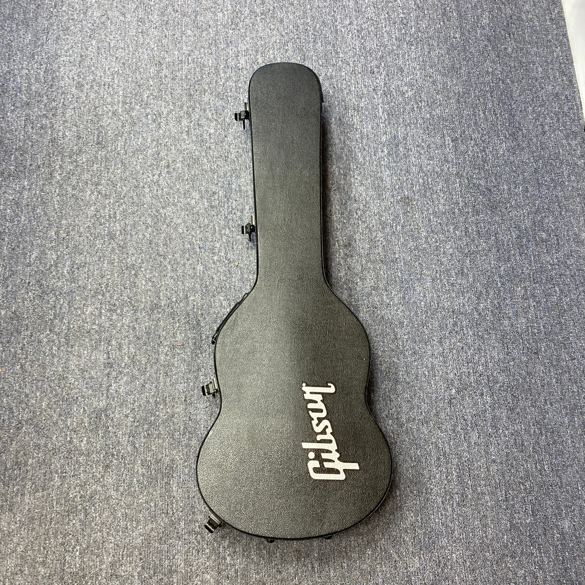 Black guitar case for the Gibson SG Modern Exclusive Dark Purple Burst Blem, positioned on a grey carpet.