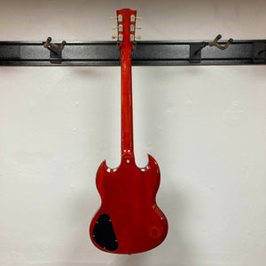A Gibson SG Standard Heritage Cherry yr 2000 Consign electric guitar, made by Gibson, hangs on a wall rack with its back showing a black plastic cover near the bottom.