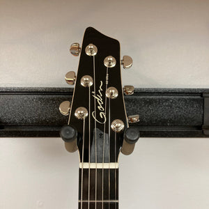 Godin A6 Ultra Koa Extreme SF guitar on a stand, featuring an electric neck, chambered body, and dual outputs for versatile sound control.
