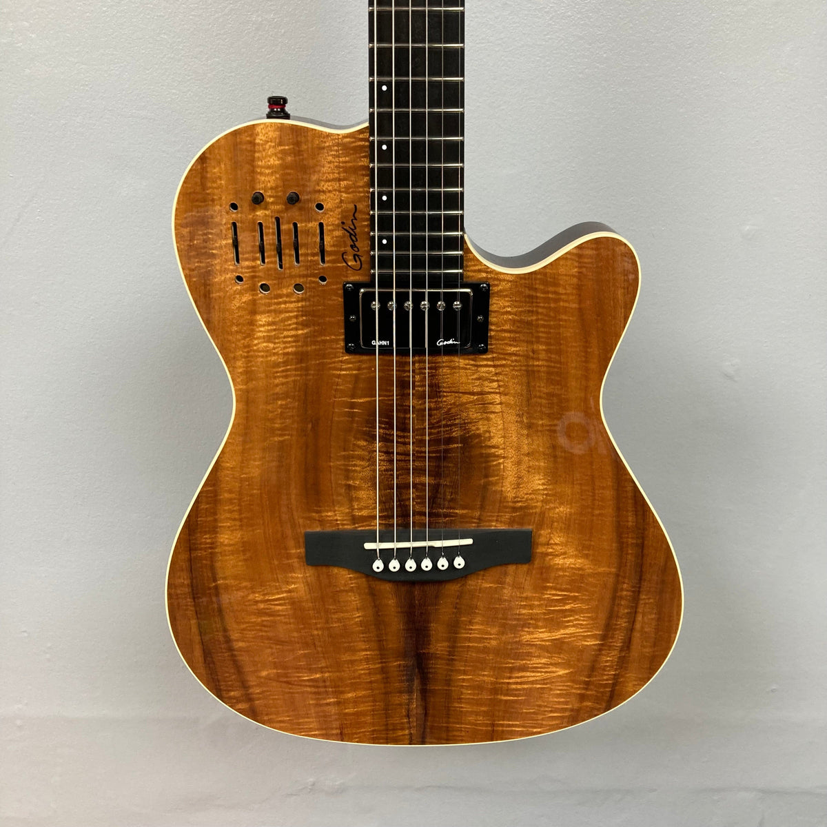 Close-up of the Godin A6 Ultra Koa Extreme SF guitar, showcasing strings and body details, highlighting its acoustic and electric features.