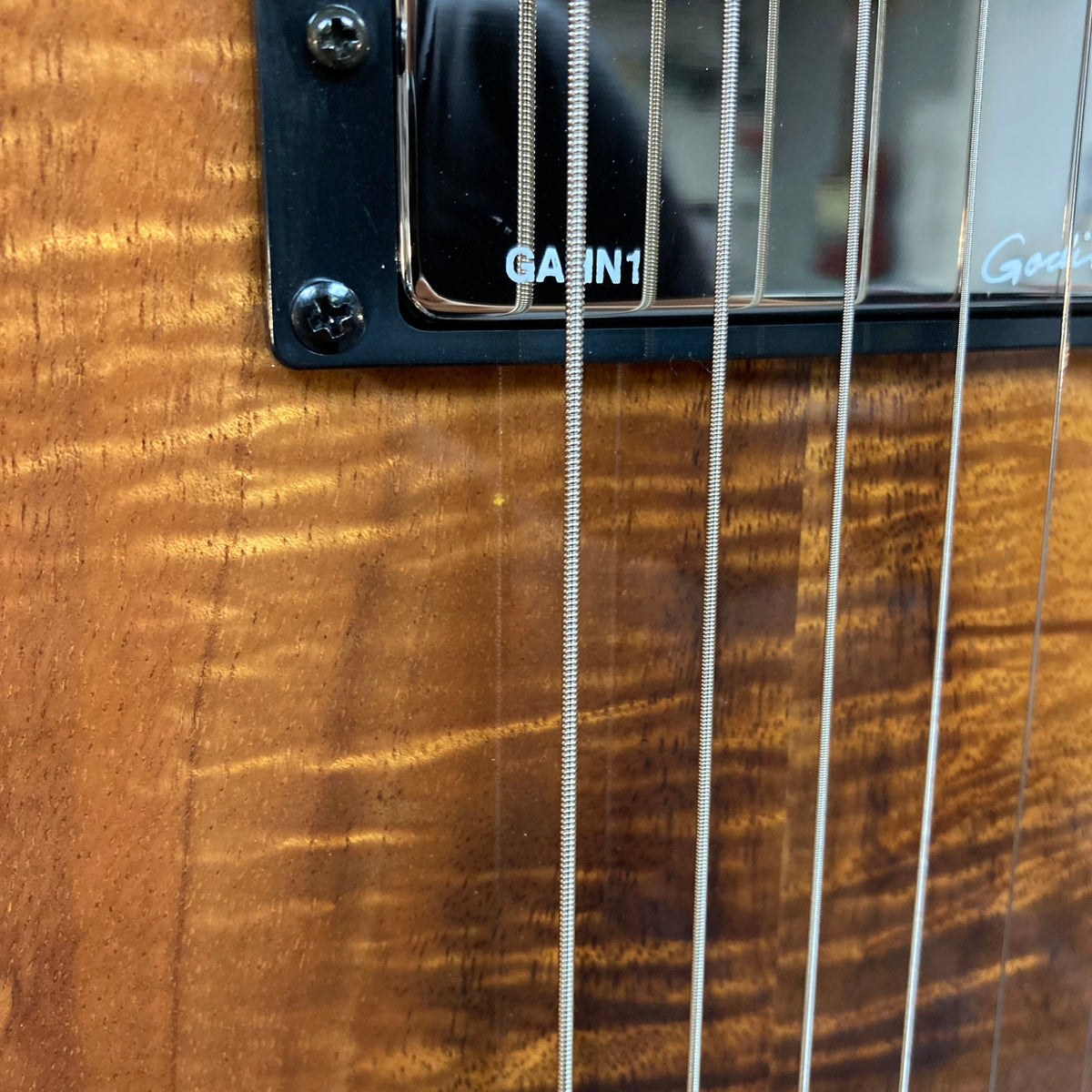 Close-up of the Godin A6 Ultra Koa Extreme SF guitar strings, highlighting the craftsmanship and innovative design for enhanced acoustic and electric performance.