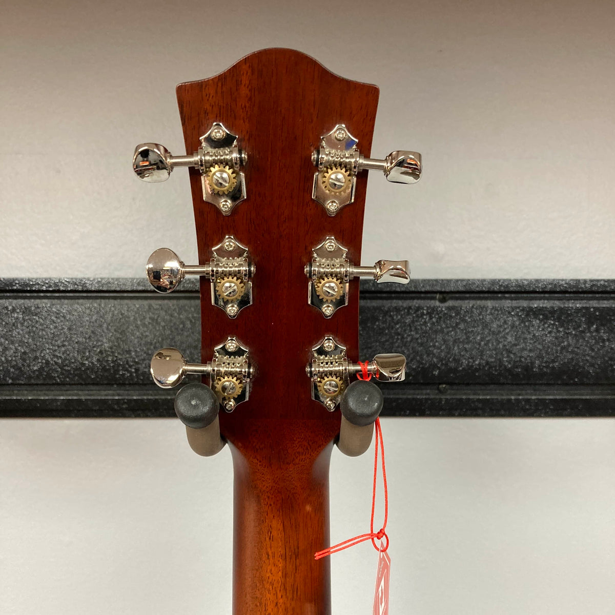 Close-up of the Godin Imperial Laguna Blue GT EQ SF Acoustic Guitar headstock showing six tuning pegs and part of the neck, with a red string tied to one peg. Brand: Godin. Gigbag included.