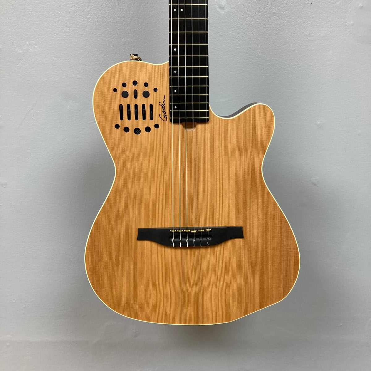 Close-up of the Godin Ltd Multiac ACS Cedar Matte SG guitar's neck and strings, highlighting its solid cedar top and custom LR Baggs electronics.