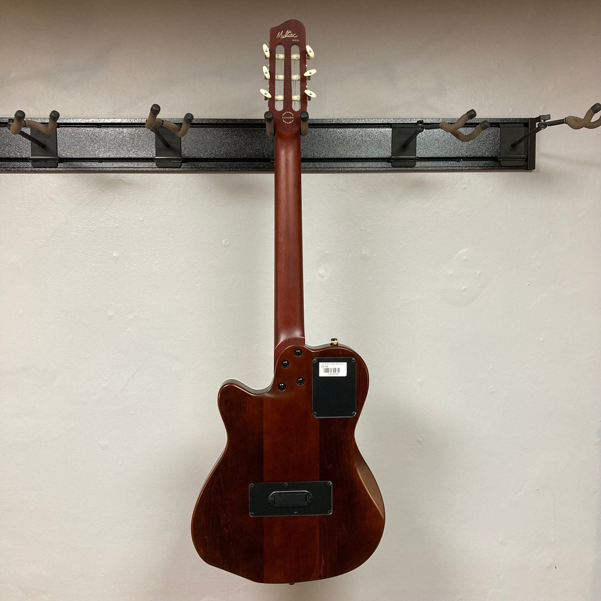 Godin Ltd Multiac ACS Cedar Matte SG w/GigBag displayed on a wall, showcasing its comfortable neck and solid cedar top design.