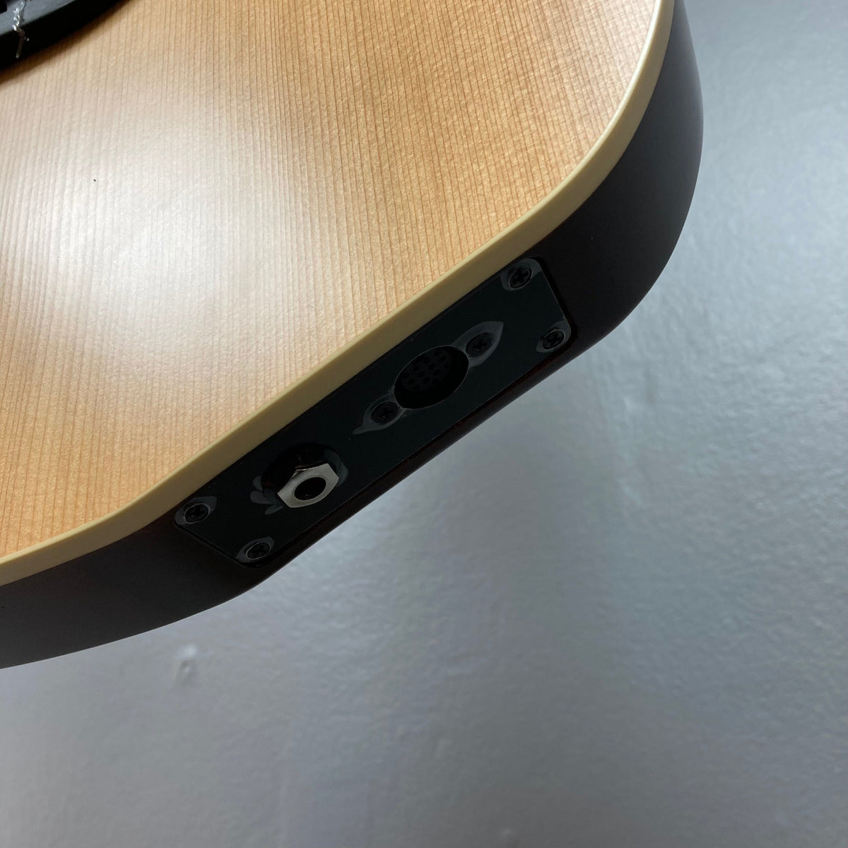 Close-up of Godin Ltd Multiac ACS Cedar Matte SG, highlighting the guitar's solid cedar top and richlite bridge, showcasing its advanced electronics and synth access capabilities.