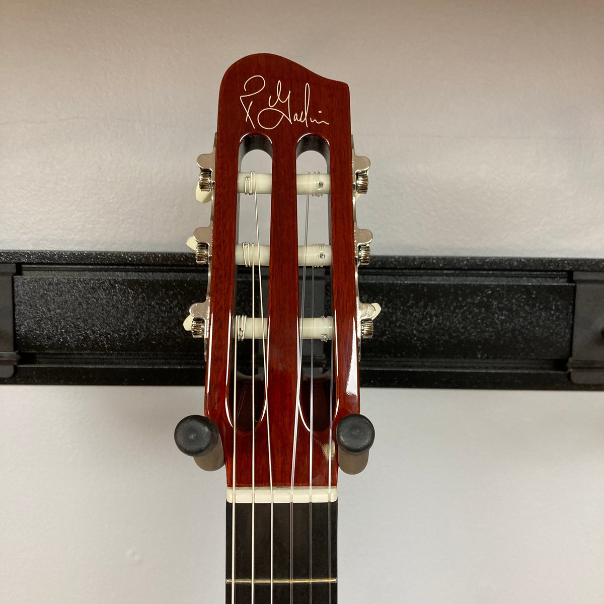 Godin Ltd Multiac ACS Cedar Matte SG w/GigBag features a close-up of the guitar head and neck on a stand, showcasing its solid body design.
