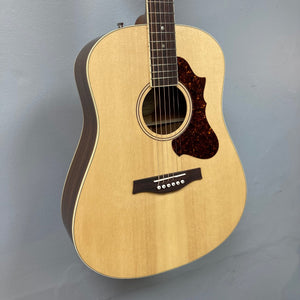 Godin Metropolis Natural RN GT EQ acoustic guitar with mahogany body, spruce top, rosewood fretboard, and Presys VT electronics, displayed on a wall.