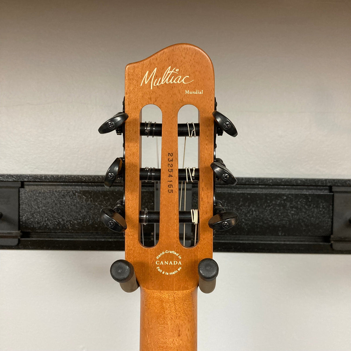 Godin Prototype Ltd Mundial Dark Cedar w/GigBag, showcasing a close-up of the guitar head, neck, and pegs, highlighting detailed craftsmanship.