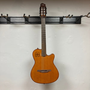 Godin Prototype Ltd Mundial Dark Cedar w/GigBag displayed on wall, showcasing its nylon strings and craftsmanship details.