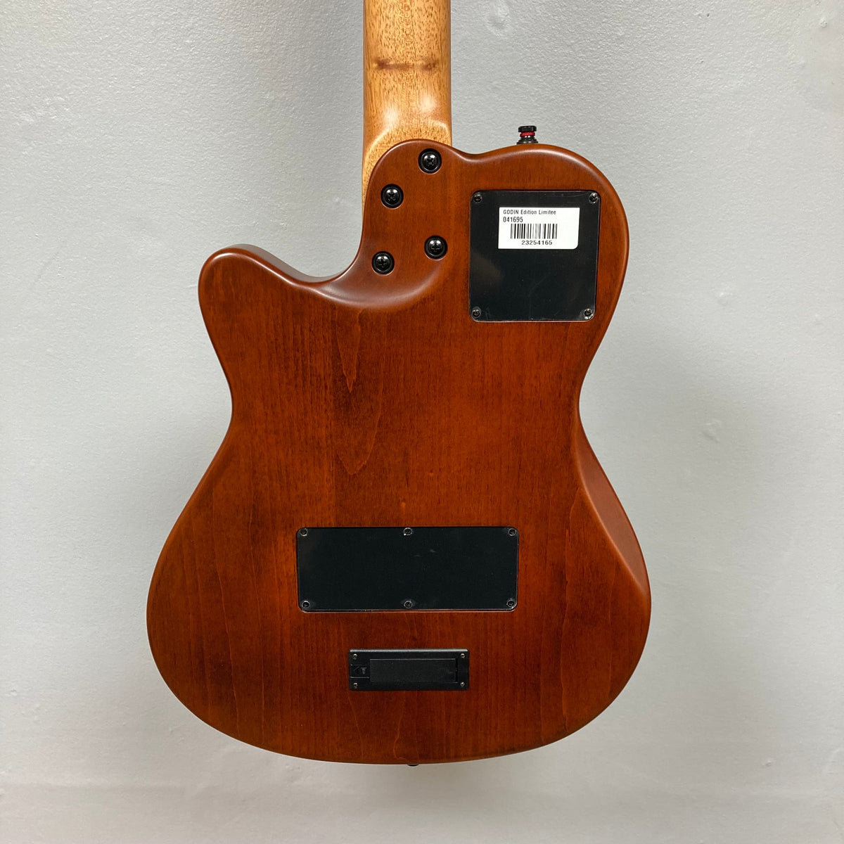 Close-up of the back of a Godin Prototype Ltd Mundial Dark Cedar w/GigBag electric guitar, showcasing its wooden body and craftsmanship.