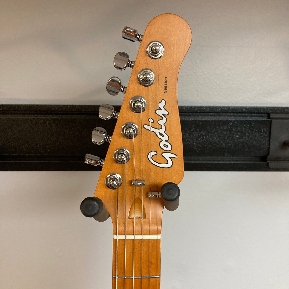 Close-up of the Godin Session HT MN Aztek Red guitar neck, showcasing high-quality hardware and craftsmanship.