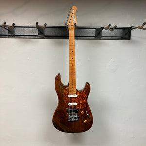Godin Session T-Pro LTD Kanyon Burst MN electric guitar on a wall hook, featuring H-S-S pickups and a sleek design.
