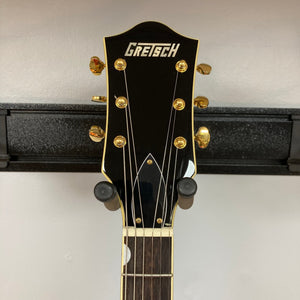 Gretsch G5420TG Electromatic Black Gold Used guitar mounted on a wall, showcasing its elegant finish and craftsmanship.