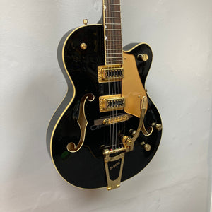 Gretsch G5420TG Electromatic Black Gold guitar with Filter'Tron pickups and Bigsby vibrato tailpiece, mounted on a wall.
