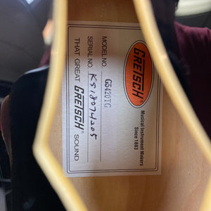 Close-up of Gretsch G5420TG Electromatic Black Gold guitar showcasing Filter'Tron pickups and Bigsby Vibrato Tailpiece, highlighting intricate craftsmanship and vintage-inspired design.