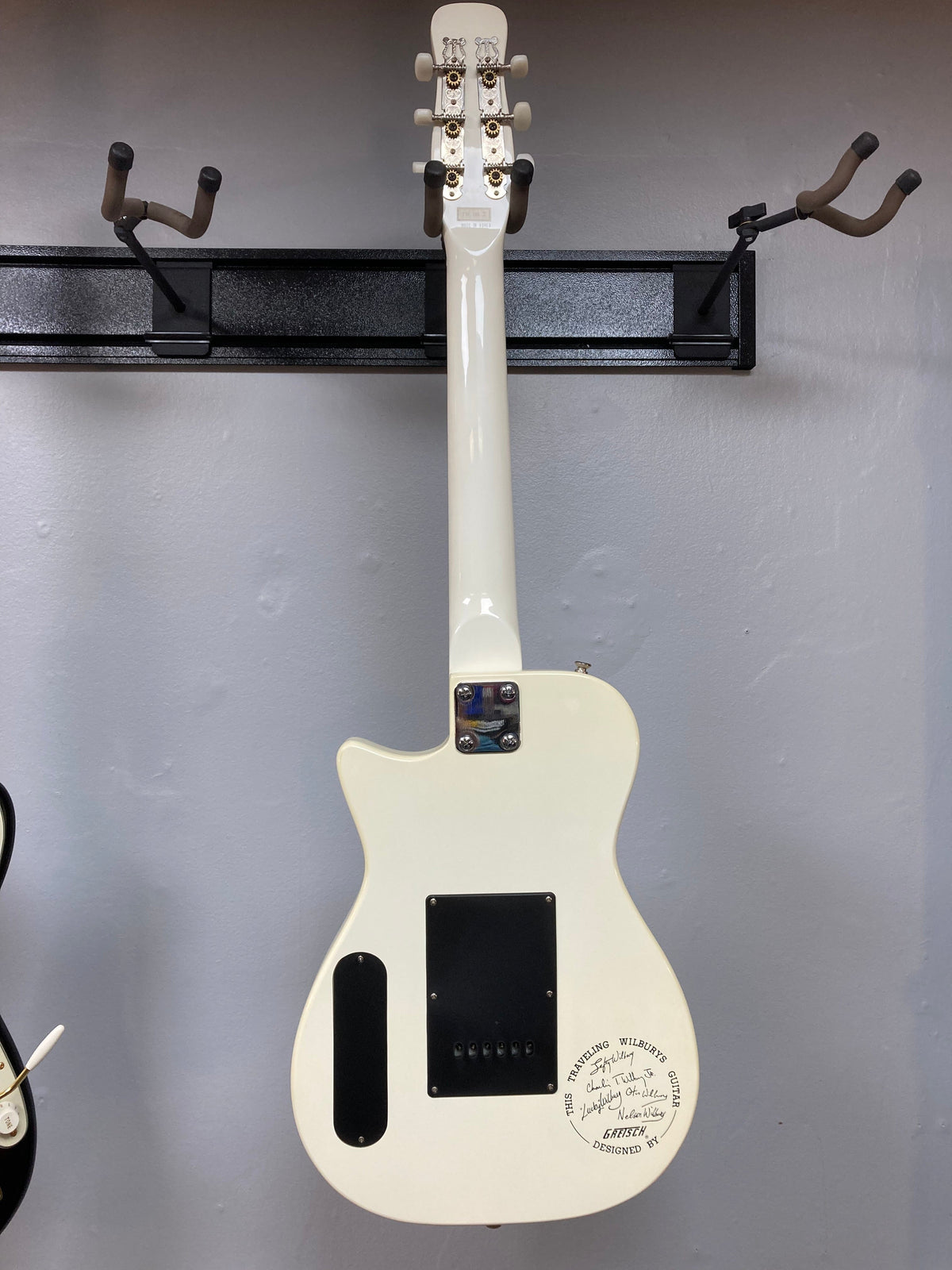 Gretsch Traveling Wilburys TW-100T Electric Guitar mounted on a wall, featuring original accessories.