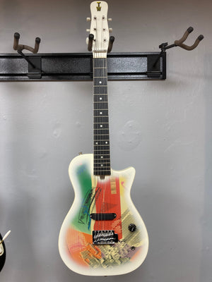 Gretsch Traveling Wilburys TW-100T Electric Guitar with colorful design, displayed on a wall.