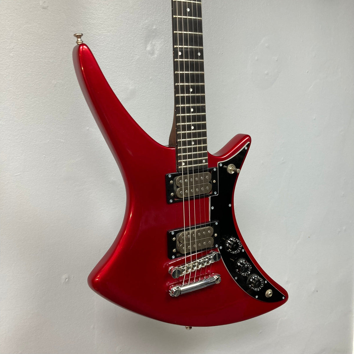 Guild USA X-79 Candy Apple Red electric guitar on display, featuring a unique body shape and professionally refinished for a vintage yet refreshed look.