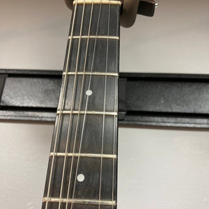 Close-up of a Guild USA X-79 Candy Apple Red guitar neck with case, showcasing its 24-fret fingerboard and unique design.