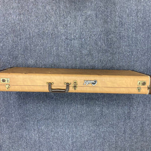 Guild USA X-79 Candy Apple Red guitar in a brown wooden case with handle, shown on a carpet.