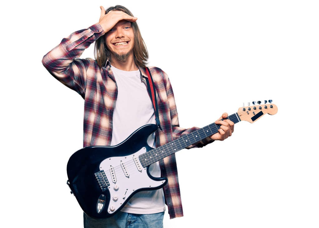 Frustrated guitar player with his hand above his eyes. Frustrated guitar player with his hand above his eyes.