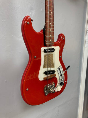 Hagstrom I vintage electric guitar with original case, featuring a deep red finish and minimal player's wear, displayed on a wall.