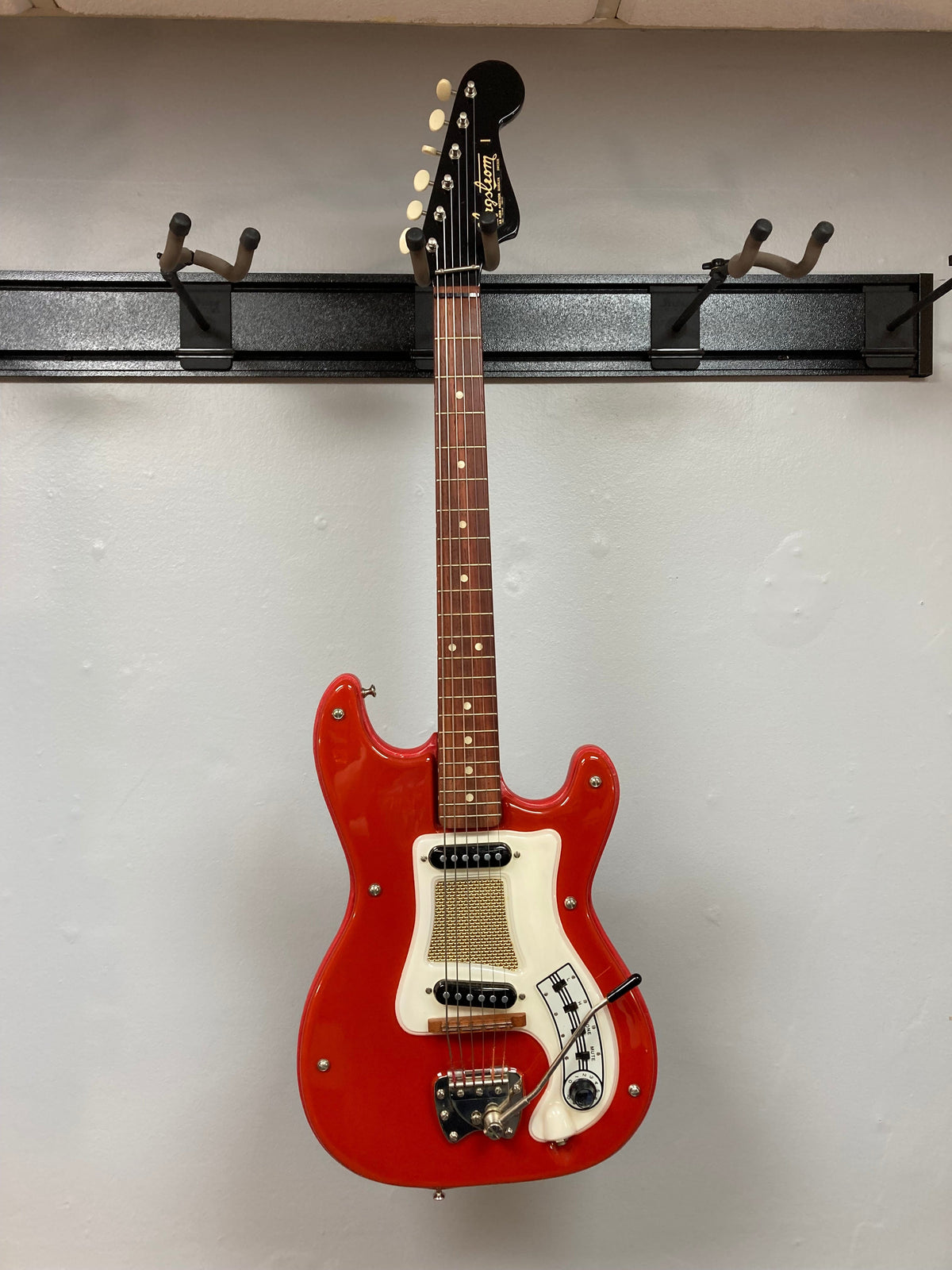 Hagstrom I vintage electric guitar, deep red, mounted on a wall, showcasing original flatwound strings and a Brazilian Rosewood fretboard.
