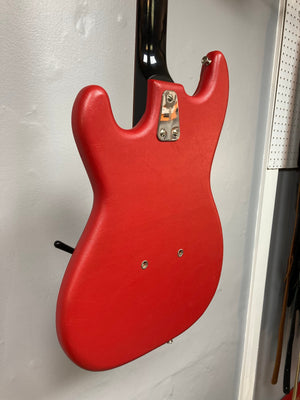 Hagstrom I vintage red electric guitar with silver hardware, displayed on a wall.