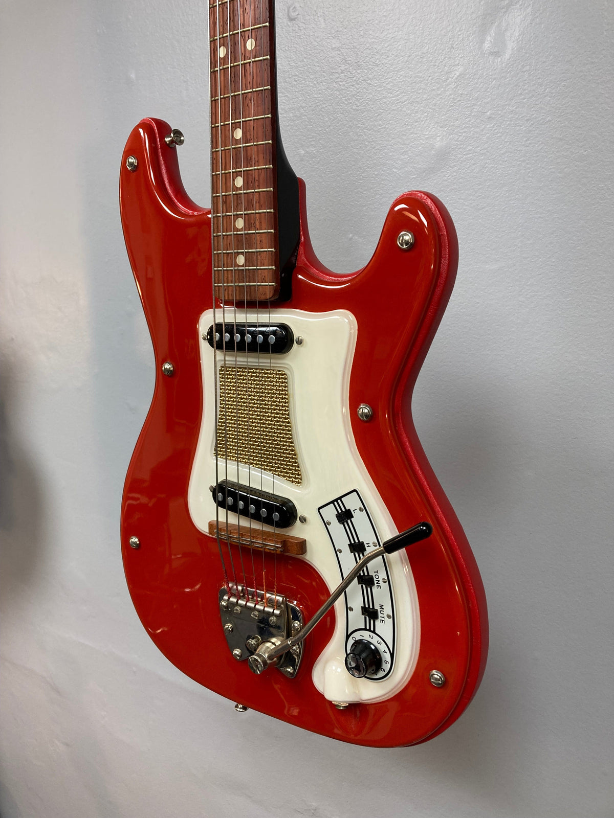Hagstrom I Vintage Electric Guitar with original case, featuring a red and white body, visible strings, and fretboard.