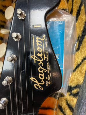 Hagstrom I vintage electric guitar close-up, showcasing strings, fretboard, and black label with gold text. Minimal wear, original flatwound strings.