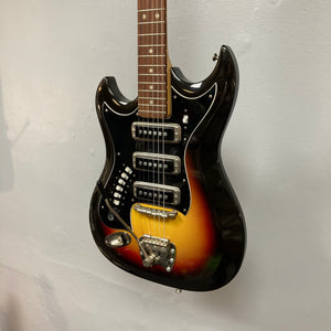 Hagstrom III Left Hand 1960s Sunburst Electric Guitar on wall, showcasing its vintage design and three single-coil pickups.