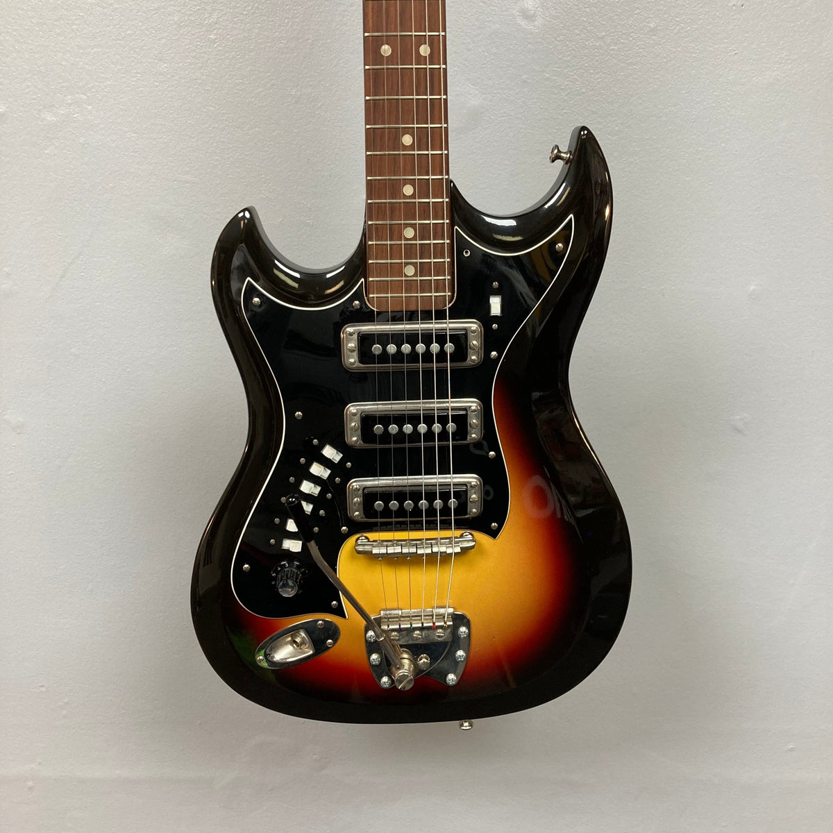 Hagstrom III Left Hand 1960s Sunburst Electric Guitar with close-up of strings displayed on a wall.