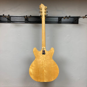 Hagstrom Viking 1968 Natural guitar mounted on a wall, showcasing its unique design and vintage craftsmanship.